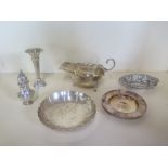 A silver sauce boat - three silver dishes - a silver pepper and a small weighted case - total silver