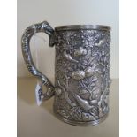 A Chinese silver tankard with blank cartouche surrounded by a relief decoration of birds amidst