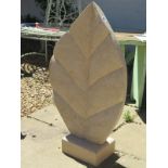A hand carved limestone leaf sculpture