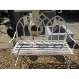 A wrought iron arch topped bench