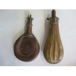 A brass powder flask and a leather powder flask, general usage wear to both