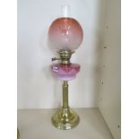 A brass oil lamp with coloured glass font and etched shade - 68cm tall, in good clean condition