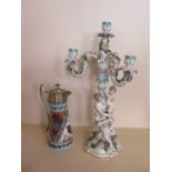 A Continental porcelain figural three branch candelabra - 52cm tall and a ceramic claret jug, with