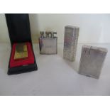 Four retro and vintage Dunhill lighters of different designs, one in yellow metal case with box, the