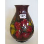 A Moorcroft vase with Hibiscus pattern upon a oxblood red ground, 21cm high