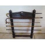 An interesting oak stick or rod rack with a selection of five walking canes