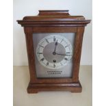 An oak case 8 day mantle clock, silvered chapter ring, retained by Harrods - running in saleroom -