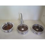 A pair of silver mounted wine coasters, 125.5 cm diameter, a larger coaster and a plated wine funnel