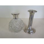 A weighted silver candlestick 14cm and a silver top cologne bottle, both with denting and wear