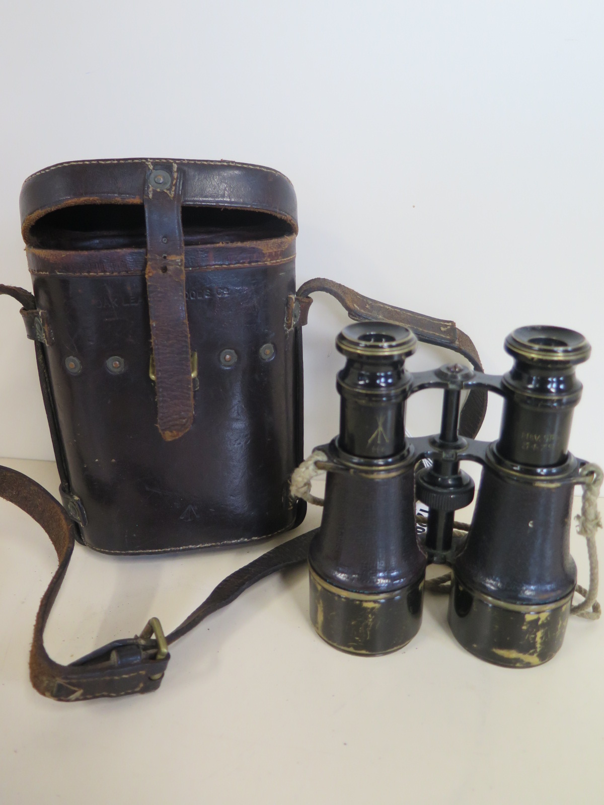 A pair of WW1 binoculars, stamped with a broad arrow MK V SPL 54791, with leather case, stamped