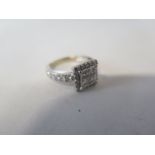An 18ct white gold diamond ring, set with four princess cut diamonds surrounded by 20 channel set