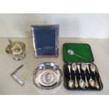 A silver milk jug, silver dish, six boxed silver spoons and a silver photo frame, an anointing spoon