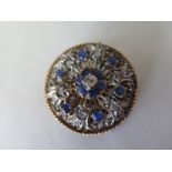 A sapphire and diamond white and yellow metal circular brooch, 30mm diameter approx 11 grams, in