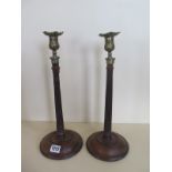 A pair of early 19th Century mahogany and brass candlesticks with weighted bases, 39cm H, old