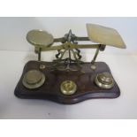 A set of brass postal scales, with some weights missing