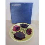 A Moorcroft Anemone pattern plate, 26cm diameter, good condition, boxed, minor crazing