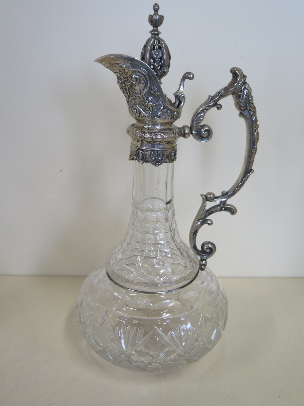 A cut glass claret jug with a silver top, marked 925 - 30cm tall, in good clean condition