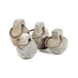 Four carved stone camel tethers, each with an iron ring handle, north African, 25.3cm high (max). (