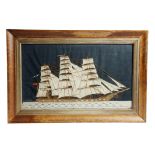 A Victorian sailor's woolwork picture, depicting a three masted sailing ship, flying the red ensign,