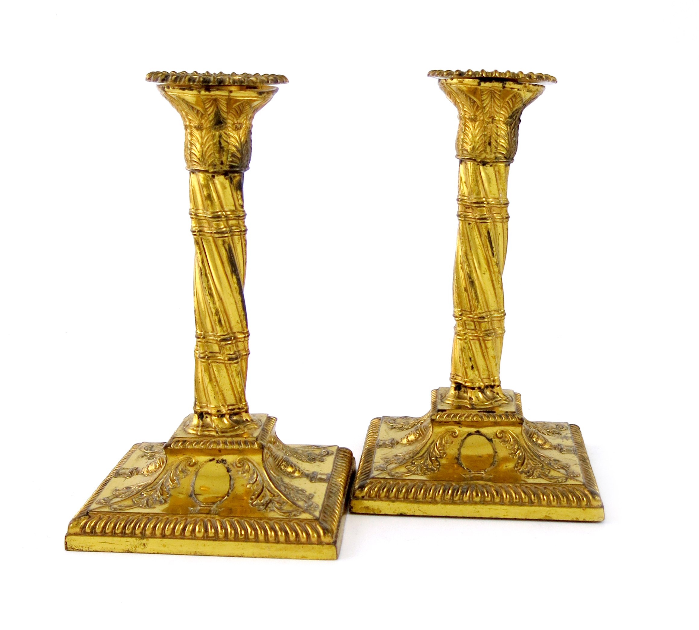 A pair of late 18th century gilded old Sheffield plated candlesticks, unmarked circa 1790, swirl-