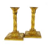 A pair of late 18th century gilded old Sheffield plated candlesticks, unmarked circa 1790, swirl-