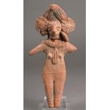 An Indus Valley terracotta votive figure of a goddess with mica, having an elaborate headdress and