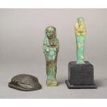 An Egyptian blue/green faience shabti Late Period, circa 664 - 332BC with adze, hoe and seed bag,