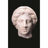 A Greek marble female head Circa 4th century BC with central parted wavy hair and wearing a veil