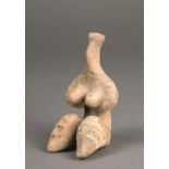 A Tel Halaf terracotta female idol circa 4th Millennium BC seated with her arms supporting her large