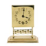 A continental Art Nouveau polished brass mantle clock, square section face with raised Arabic