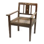 A continental Secessionist oak armchair, with rattan seat, the back inlaid with pewter and ivory