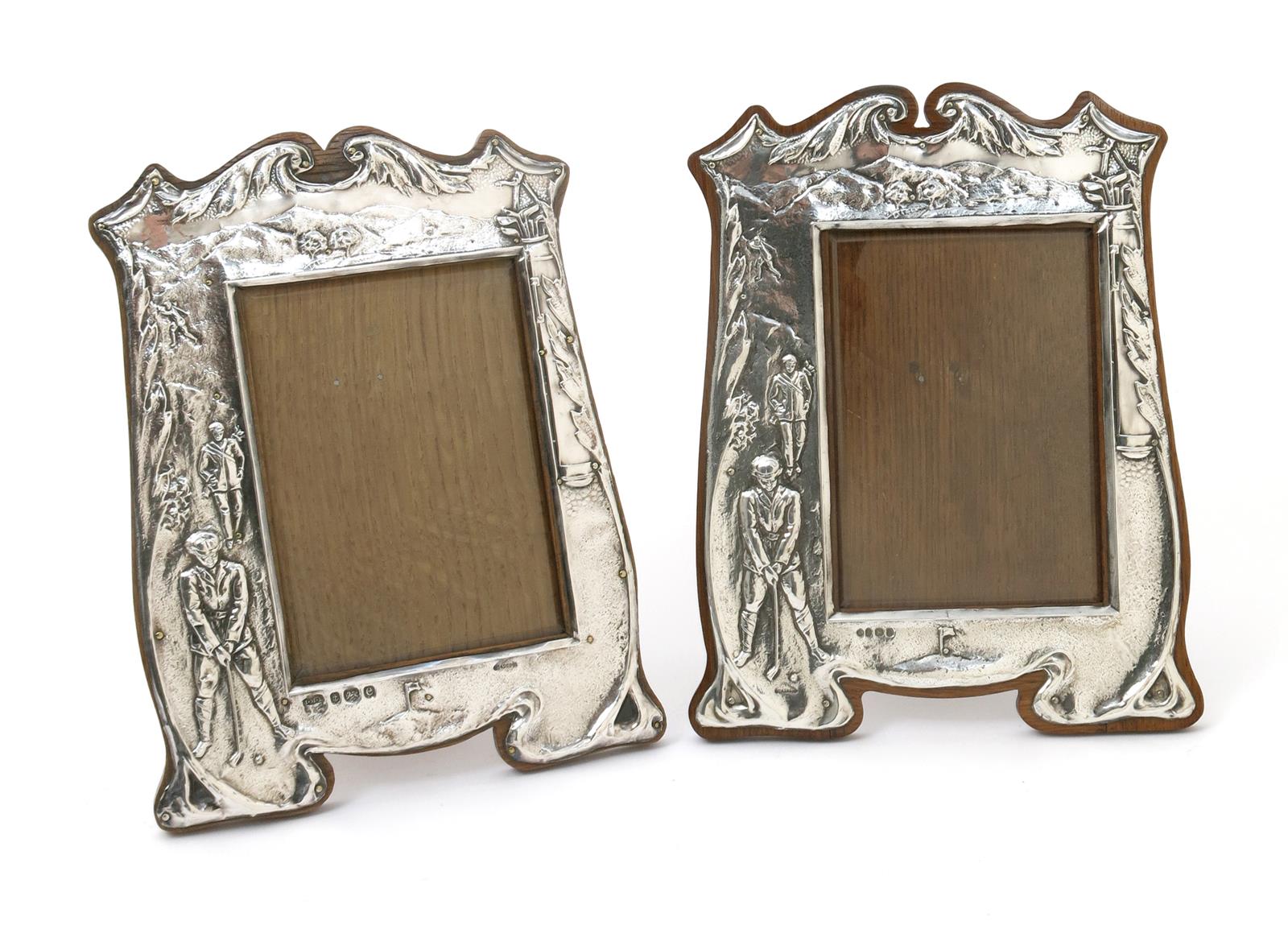 A pair of John Millward Banks silver photograph frames, each stamped in low relief with an Edwardian
