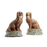 A rare pair of mid-Victorian Scottish pottery models of spaniels, with a treacle glaze, each with