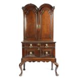 An early 18th century oak cabinet on stand, the double domed top with a pair of shaped panelled