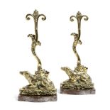 A pair of early 19th century brass dog doorstops, each modelled with a recumbent spaniel on a