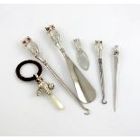 A small collection of six novelty silver owl handled items, comprising: a button hook and shoe horn,