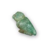 A carved emerald owl, with bead eyes and carved feathers, 3.5cm long