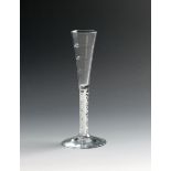 A rare Lynn ratafia glass, c.1765, the narrow drawn trumpet bowl moulded with horizontal ribs,