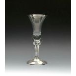 A pedestal stem wine glass, c.1720, the generous bell bowl raised on a six-sided pedestal stem above