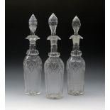 Three cut glass decanters and stoppers, 19th century, the tall bottle forms with vertical flutes and