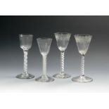 Four wine glasses, c.1760-70, a pair with round funnel bowls moulded around the base and engraved