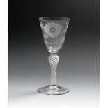 A Jacobite goblet, c.1760, the generous funnel bowl engraved with a six-petalled rose and bud spray,