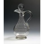 A glass claret jug and stopper, late 18th/early 19th century, the rounded body engraved '