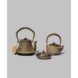 TWO JAPANESE CAST-IRON KETTLES AND COVERS, TETSUBIN EDO/MEIJI PERIODS One of tapering form decorated