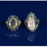 A silver ring the design attributed to Kate Eadie, with cast gold flowers to the shoulder and set