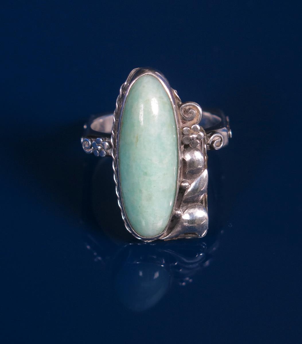 A silver and Amazonite ring, wide, slender amazonite on cast, off-set foliate mount, the shank of