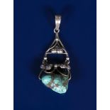 A silver and turquoise pendant possibly Liberty & Co, cast with berried foliage and set with a