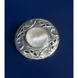 A Celtic silver and mother of pearl brooch, circular, pierced and cast with an entrelac border,