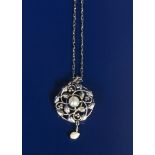 A Liberty & Co silver pendant by William H Haseler, the pierced and chased circular pendant with