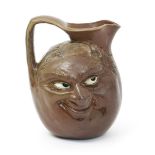 A rare Martin Brothers stoneware double sided face jug, dated 1903, modelled in relief with a